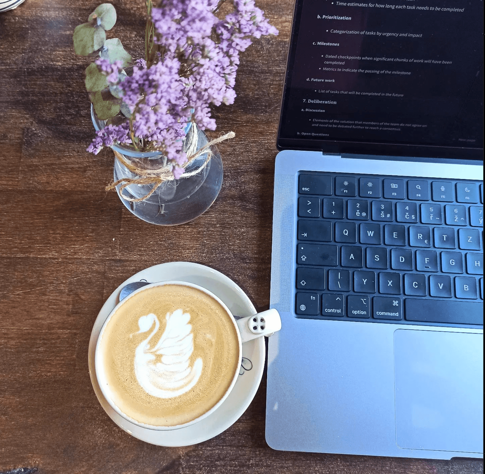 corner of a monitor with code on it with iced coffee next to it